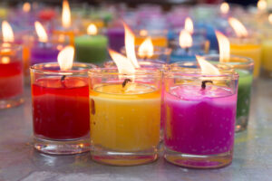 red, yellow and pink candles in jars