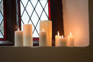 Pillar candles of different sizes under the sunlight